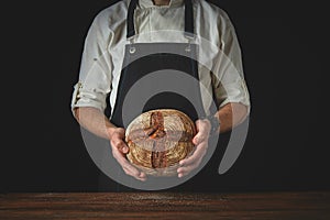 Fresh round bread male hands holding