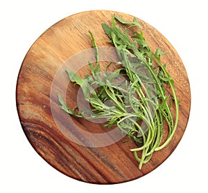 Fresh Rucola on a round wooden board