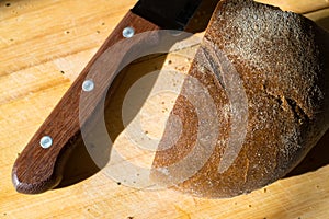 Fresh rye bread and knife on the table with crumbs