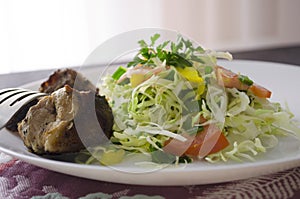 Fresh salad, barbecue, skewers on skewers with potato chips, lettuce and fresh homemade cucumbers