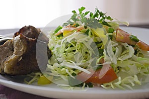 Fresh salad, barbecue, skewers on skewers with potato chips, lettuce and fresh homemade cucumbers