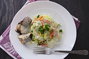 Fresh salad, barbecue, skewers on skewers with potato chips, lettuce and fresh homemade cucumbers