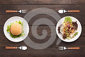 Fresh salad and burger on the wooden background. contrasting foo photo