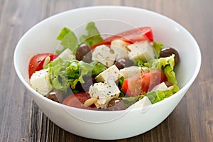 Fresh salad cheese with vegetables in white bowl