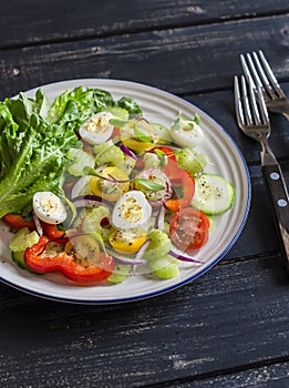 Fresh salad with cherry tomatoes, cucumbers, sweet peppers, celery and quail eggs.