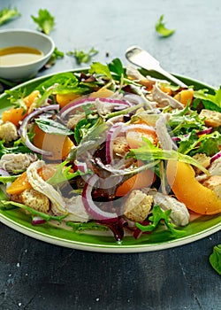 Fresh salad with chicken breast, peach, red onion, croutons and vegetables in a green plate. healthy food