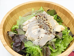 Fresh salad with chicken breast quinoa, baked bread in a wooden Tray And pumpkin salad dressing on the red cloth isolate white