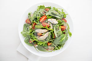 Fresh salad with chicken, tomato and greens (spinach, arugula)