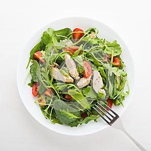 Fresh salad with chicken, tomato and greens (spinach, arugula) top view