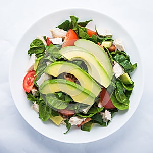 Fresh salad with chicken, tomatoes, spinach and avocado on white background top view