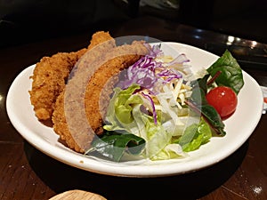 A fresh salad with crispy fried chicken tenders.