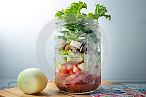 Fresh salad in a glass jar.