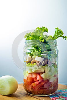 Fresh salad in a glass jar.