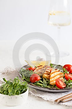 Fresh salad with grilled halumi cheese, cherry tomatoes and arugula. copy space