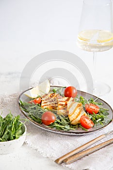 Fresh salad with grilled halumi cheese, cherry tomatoes and arugula. copy space