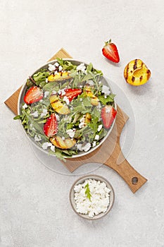 Fresh salad with grilled peaches, strawberries and cottage cheese.