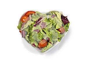 Fresh salad in heart shaped bowl