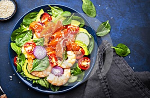 Fresh salad for keto diet with salmon, avocado, spinach, cucumber, shrimps, tomato, cashew, sesame seeds. Low-carbohydrate lunch