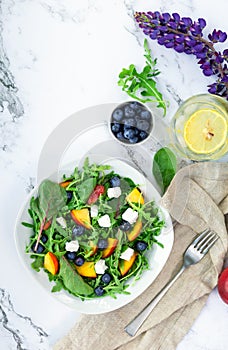 Fresh salad with nectarines, blueberries, arugula, spinach and feta cheese