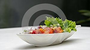 Fresh Salad with Onion and Tomatoes isolated on outdoor table.