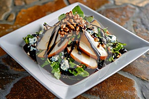 Fresh Salad With Pears, Blue Cheese, Walnuts, and Balsamic Drizzle on Rustic Stone Background