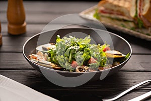 Fresh salad plate with shrimp and arugula on wooden table background. Healthy food