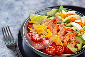 Fresh salad with prawns, avocado, eggs, bell pepper, tomatoes and herbs