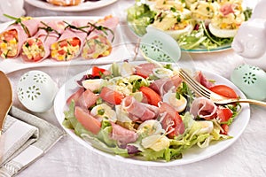 Fresh salad with quail eggs and prosciutto ham for Easter breakfast