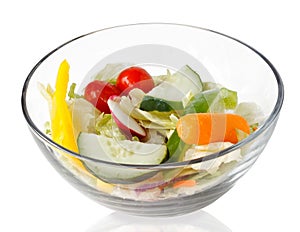 Fresh salad of raw vegetables in a glass bowl isolated on white background