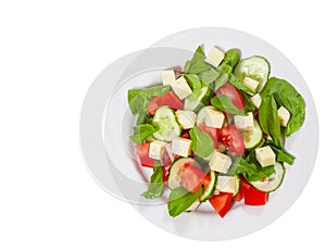 Fresh salad with tomatoes, arugula, cucumber and cheese cubes. top view. isolated