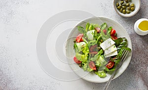 Fresh salad with tomatoes, cucumbers, capers, feta and mixed salad leaves