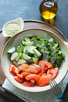 Fresh salad with tomatoes, cucumbers, herbs and hemp seeds