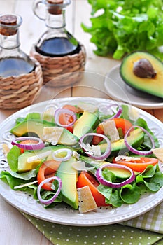 Fresh salad with tomatoes, lettuce, onions, avocado and parmesan cheese