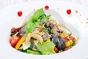 Fresh salad with tuna, arugula, artichokes, codfish, olives, basil, sun dried tomatoes, cherry tomatoes, cucumber, cauliflower