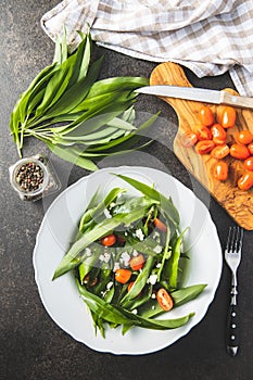 Fresh salad with wild garlic,tomatoes and feta cheese on plate