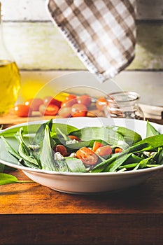 Fresh salad with wild garlic,tomatoes and feta cheese on plate