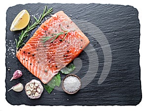 Fresh salmon on the black cutting board.