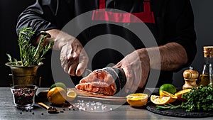 Fresh salmon with dill. chef cuts with knife the salmon. Salmon steak raw fish and ingredients prepared for cooking. concept for