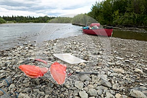 Fresh salmon fillets and river canoe in Alaska
