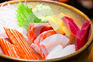 Fresh salmon fish slice with tuna set.Sushi Set Sashimi and sushi rolls served on black stone slate.Close Up.