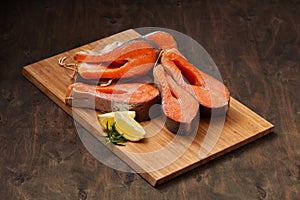 Fresh salmon fish steaks on the wooden cutting board