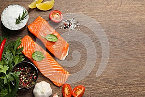 Fresh salmon and ingredients for marinade on wooden table, flat lay. Space for text