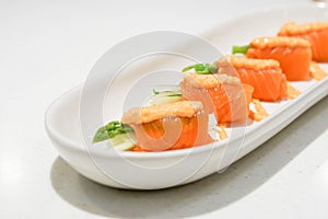 Fresh salmon roll in a white plate with selective focus