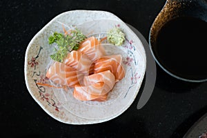 Fresh salmon sashimi fish fillet on dish served with fresh wasabi