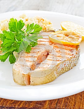 Fresh salmon served with rice parsley lemon