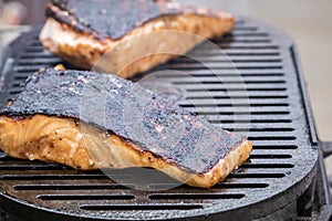 Fresh Salmon steak cooking on iron grates skin side up photo