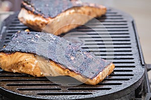 Fresh Salmon steak cooking on iron grates skin side up