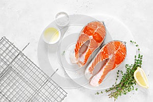 Fresh salmon steaks with ingredients for cooking on white board