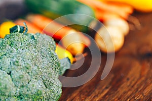 fresh salubrious colourful vegetables on wooden background, broccoli in focus, potatoes, carrots, zucchini unfocused, selected photo