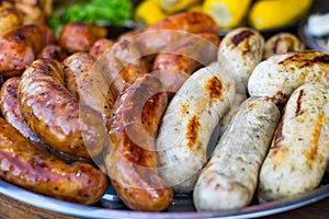 Fresh sausage and hot dogs grilling outdoors on a gas barbecue grill